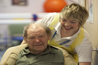 staff helping patient in wheelchair